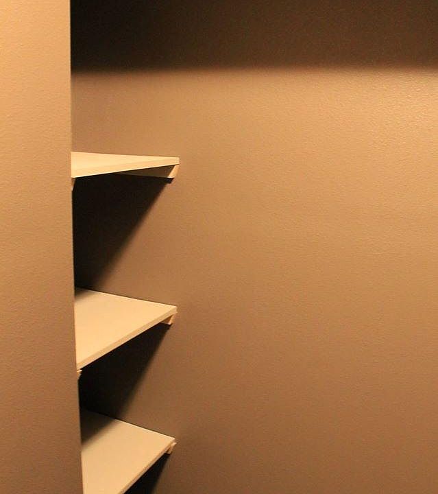 Wood shelving in walk in closet