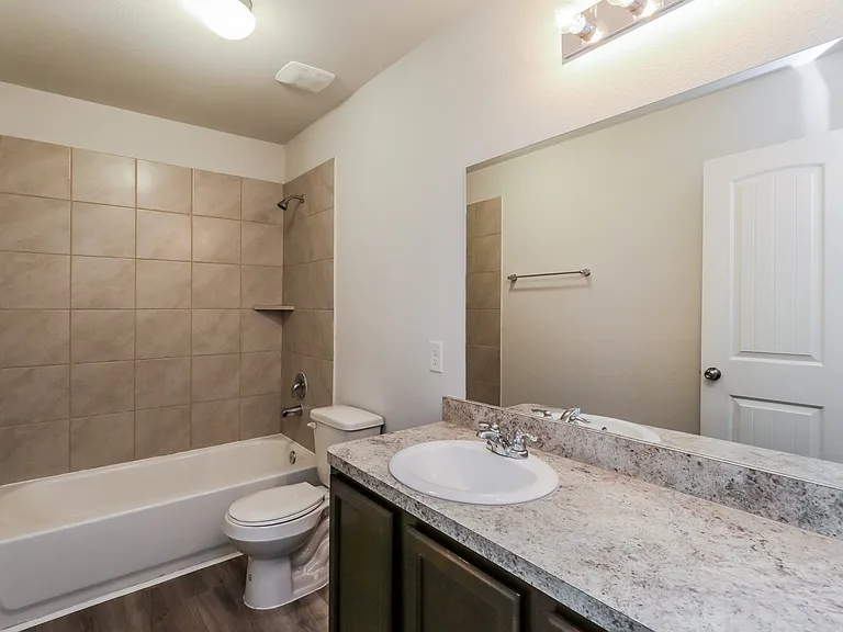 Modern bathroom with a sleek granite countertop, tiled shower, and elegant lighting fixtures. Modern bathroom with a sleek granite countertop, tiled shower, and elegant lighting fixtures.
