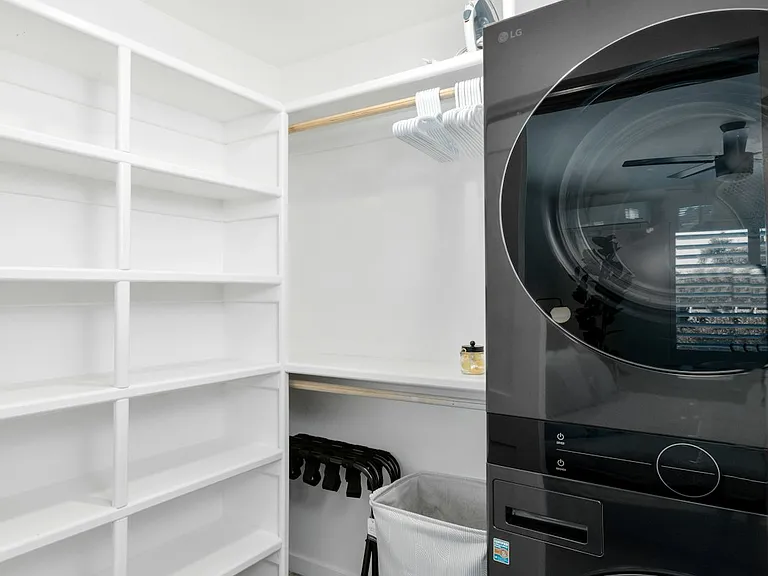 Stackable washer and dryer in the walk-in closet.