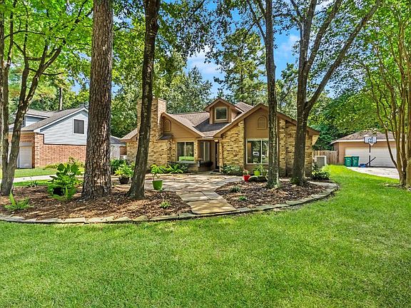 The front yard welcomes you with mature shade trees and a flagstone patio.