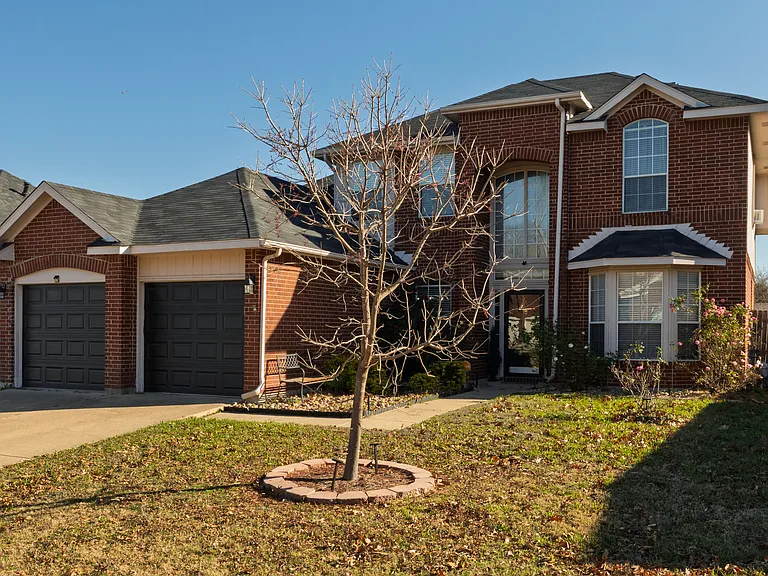 Stunning red brick two-story home with a two-car garage.