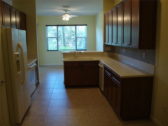 Open kitchen to the eating area. The bar has room for several stools and there is a pantry. Note the preserve out the window. There are sliders from the eating area to the back porch.
