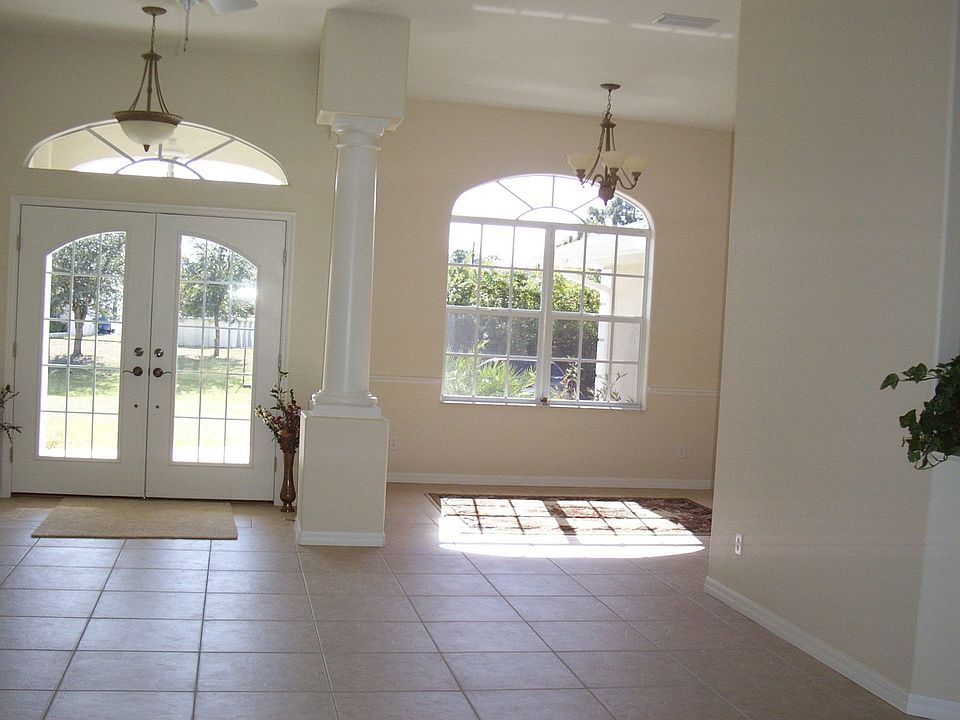 LIVING ROOM LOOKING AT FRONT ENTRY AND DINING ROOM ALL WITH HIGH CEILINGS 