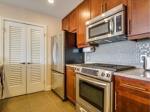 Kitchen with new LG appliances: stove, fridge, microwave, dishwasher Full-size Whirlpool washer and dryer behind louvered doors
