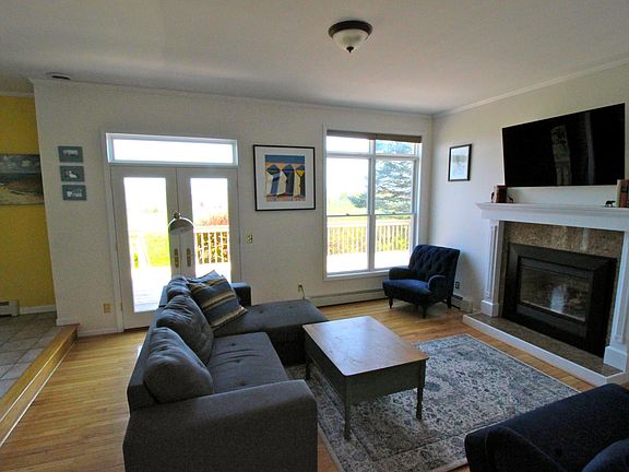 Living room with fireplace and door leading to deck/balcony.
