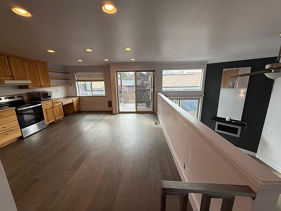 View from top of the stairs that shows split level view of the kitchen and living room.
