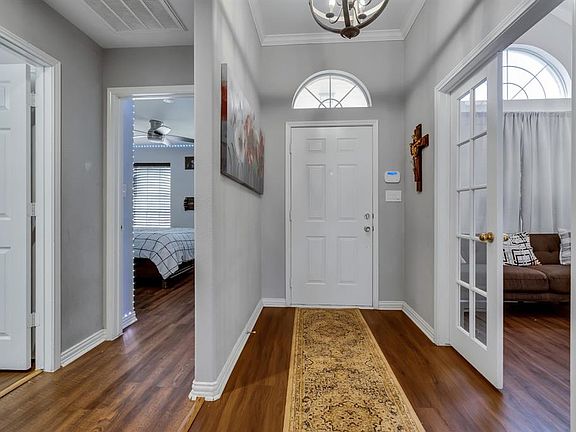 Entryway featuring ornamental molding, dark wood-type flooring, and a wealth of natural light