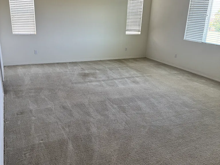 View of large main bedroom with ceiling fan/lighting and large walk-in closet.
