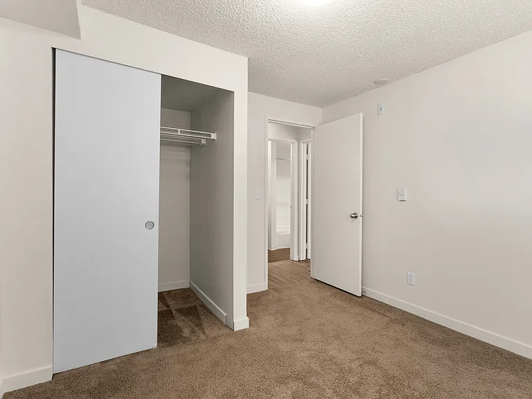 Step into comfort with this airy bedroom, featuring a stylish closet and soft carpeting. Step into comfort with this airy bedroom, featuring a stylish closet and soft carpeting.