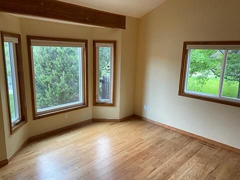 Bright and airy living room with vaulted ceilings, hardwood floors and exposed beams