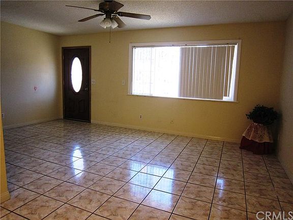 Living Room with tiles flooring, dual pane window, ceiling fan.
