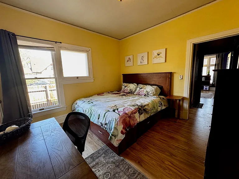 Bedroom 2. King-sized Captain's bed with four large drawers and memory foam mattress. Tall dresser. Desk and chair. Large closet with two rows to hang clothes. The room is bright but also has room darkening shades.