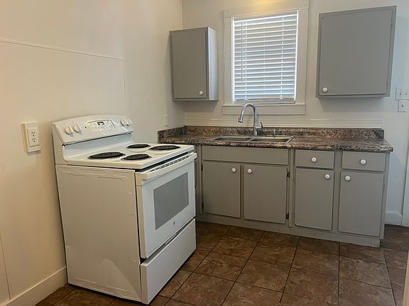Eat in kitchen with electric oven/stove and new refrigerator around the corner.