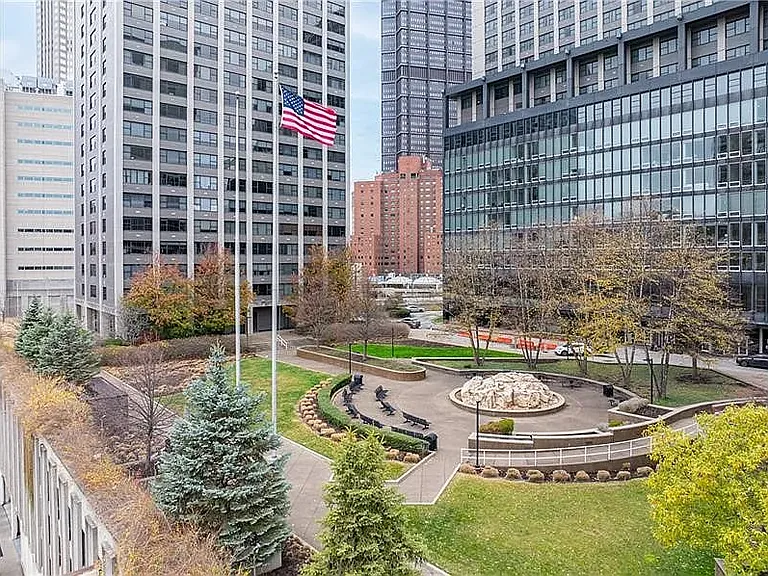 Apartment overlooks private courtyard, fountain, greenery, and outdoor seating.