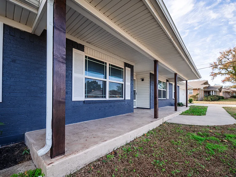 Covered front porch entrance with blue siding and attached garage