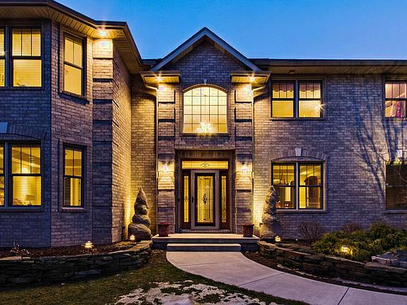 A statement in luxury, landscape lighting illuminates the architectural features of the stunning exterior.