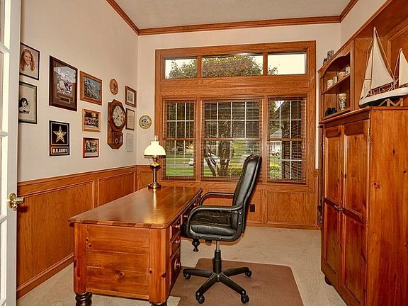 Study with 11' ceiling, glass French doors, large windows, custom built-in bookcases, wainscoting and crown molding.