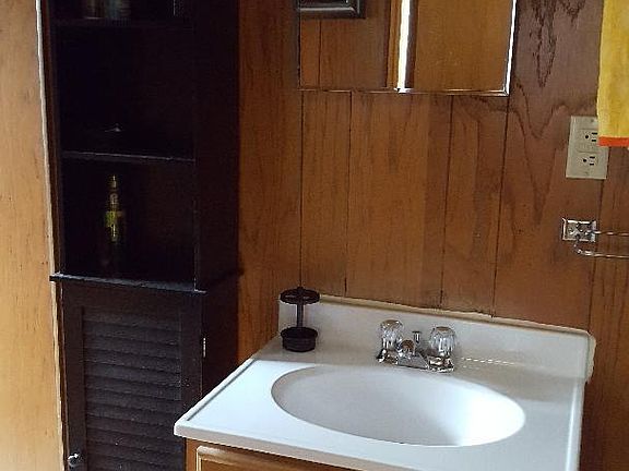 vanity in bathroom area, shower stall only to the left and toilet to left.