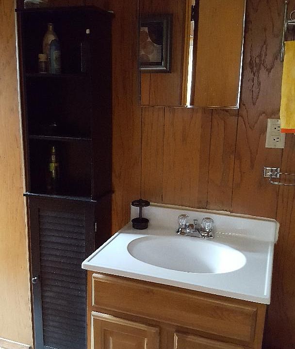 vanity in bathroom area, shower stall only to the left and toilet to left.