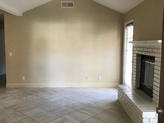 Living room with lots of natural light and a door to go out to side yard and back yard.