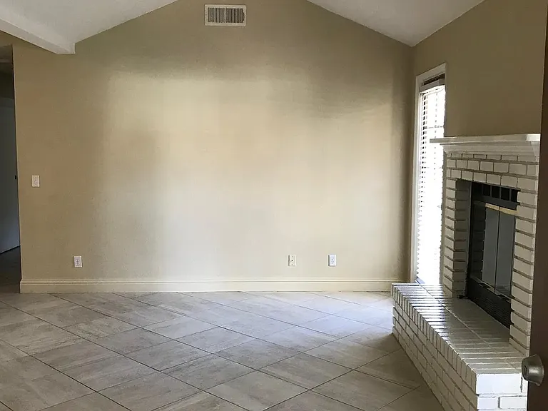 Living room with lots of natural light and a door to go out to side yard and back yard.