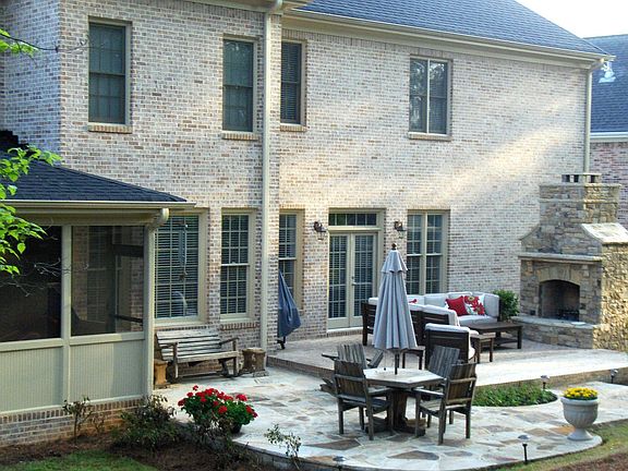 Backyard has screened in porch, masonry fireplace and two patio areas