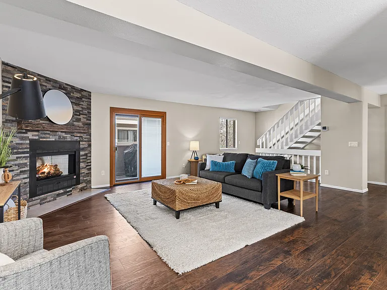 The thoughtfully designed main level welcomes you with an open floor plan, updated flooring, spacious living and dining areas, and a decorative tiled fireplace.
