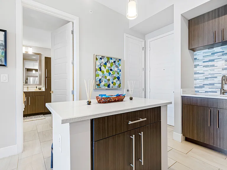 Model kitchen and dining room at our apartments in Boca Raton, featuring chairs around a table and counter seating.