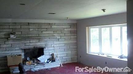 Living room : Large fireplace in living room with a new large bay window.