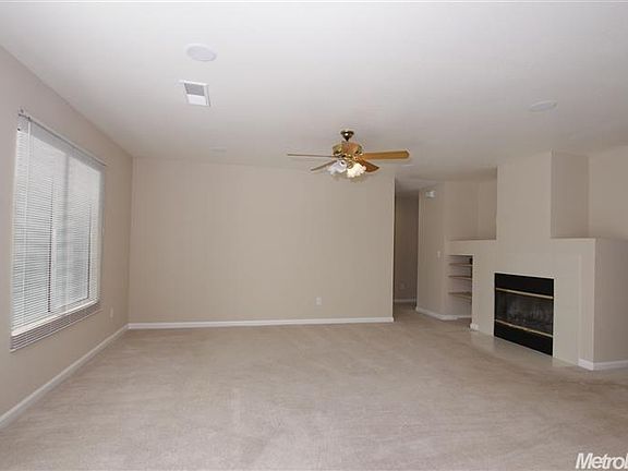 family room with fireplace and ceiling fan
