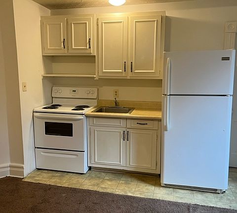 Another look at kitchen which is open to a very large living room. The listing has three rooms: 1) Kitchen/living combo
2) Standard full bath with shower
3) Large bedroom with decorative fireplace and large closet with clothes rod, a rarity for Highlands