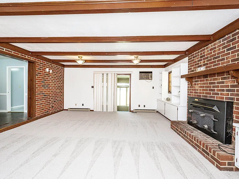 Massive 2nd living room with new paint, exposed beams and charming brick fireplace.
