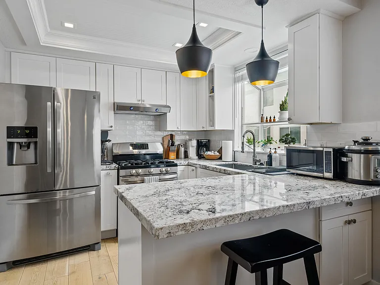 This kitchen is a symphony of marble countertops, stainless steel appliances, and custom cabinetry, offering both beauty and practicality in equal measure.
