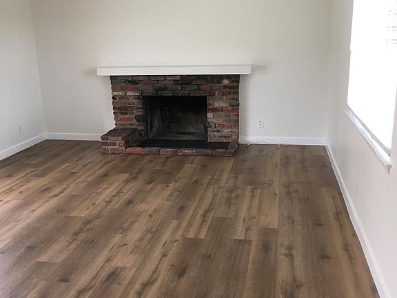 Living room area with brick fireplace.