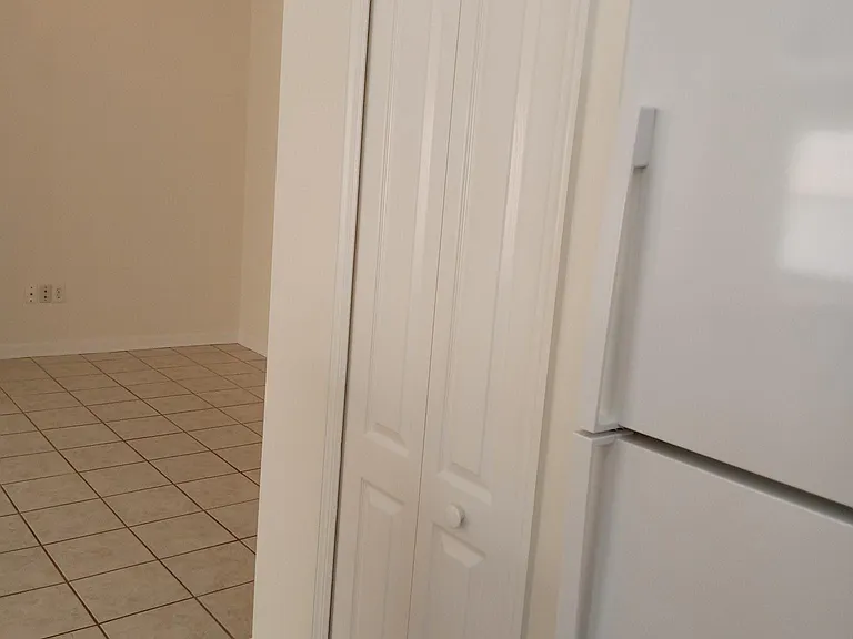 Walk-in food pantry doorway next to the refrigerator.