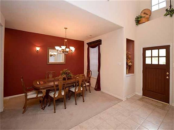 Formal dining room with updated chandelier. Art niche above front door