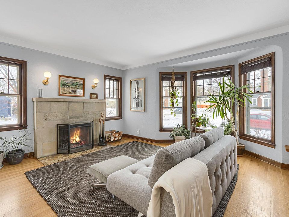 Spacious living room with refinished hardwood floors, bay window and wood-burning fireplace
