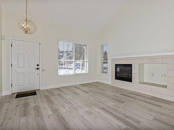 Family room with new tile flooring and gas log fireplace. Vaulted ceiling with skylight allows the room to be bathed in sunlight