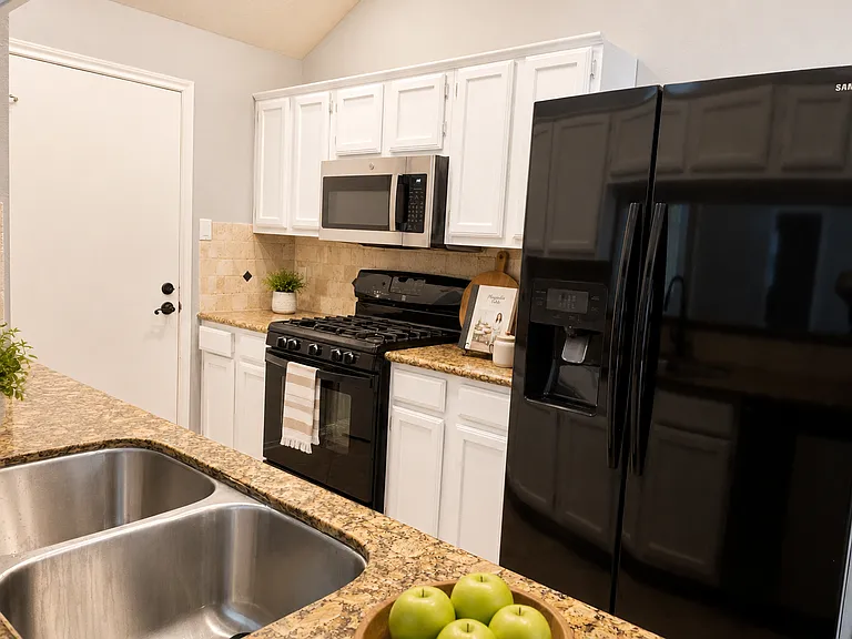 kitchen stove, microwave stove with ventilation, refrigerator, staged