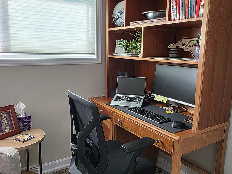 The office desk has a hutch for storage and comfortable desk chair.