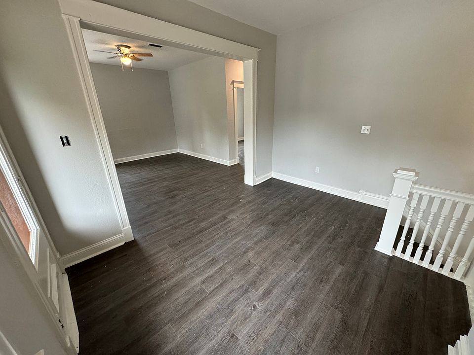 Semi-divided living room with ceiling fans, natural light and coat closet