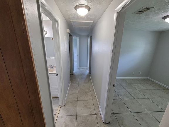 Bright, well-lit hallway connecting the master bedroom, two additional bedrooms, and the main bathroom, featuring two convenient closets for extra storage.