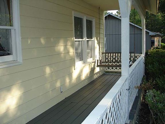 Comfortable front porch with a swing and privacy from the road.