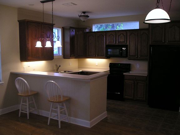 Open kitchen with wood cabinets, corian counters