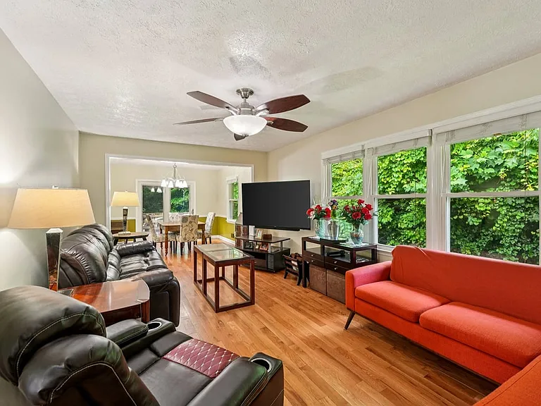 This cheerful gathering space feels like a cozy storybook lounge, with garden views, rich wood tones, and plenty of room to relax, unwind, and feel at home.