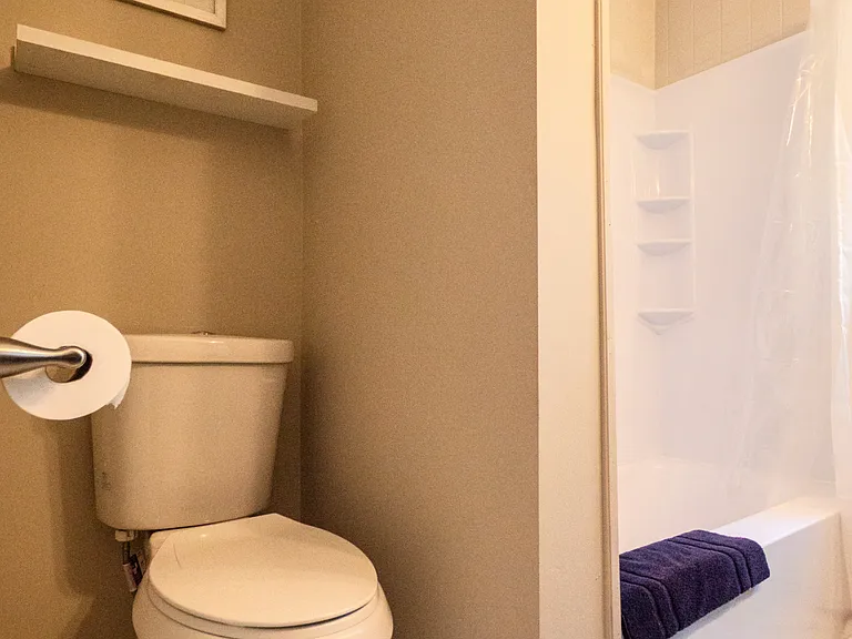 En suite bathroom toilet niche, tub has handicap bar
