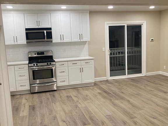 Kitchen view from the entrance. Balcony through the sliding door.