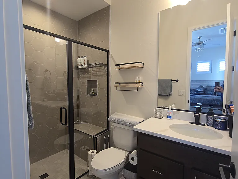 Room A features a cozy lounge with a mounted TV over an electric fireplace, leather sofa, marble-top coffee table, ambient lighting, and a kitchenette. Sliding glass doors open to a private courtyard