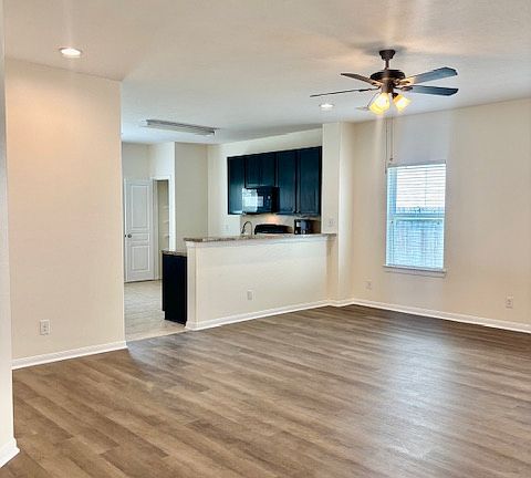 Large Family Room with recessed lighting, ceiling fan, natural light.