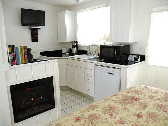 Hummingbird cottage, looking towards the kitchen with convection oven, built in fridge, gas cooktop, and electric fireplace.